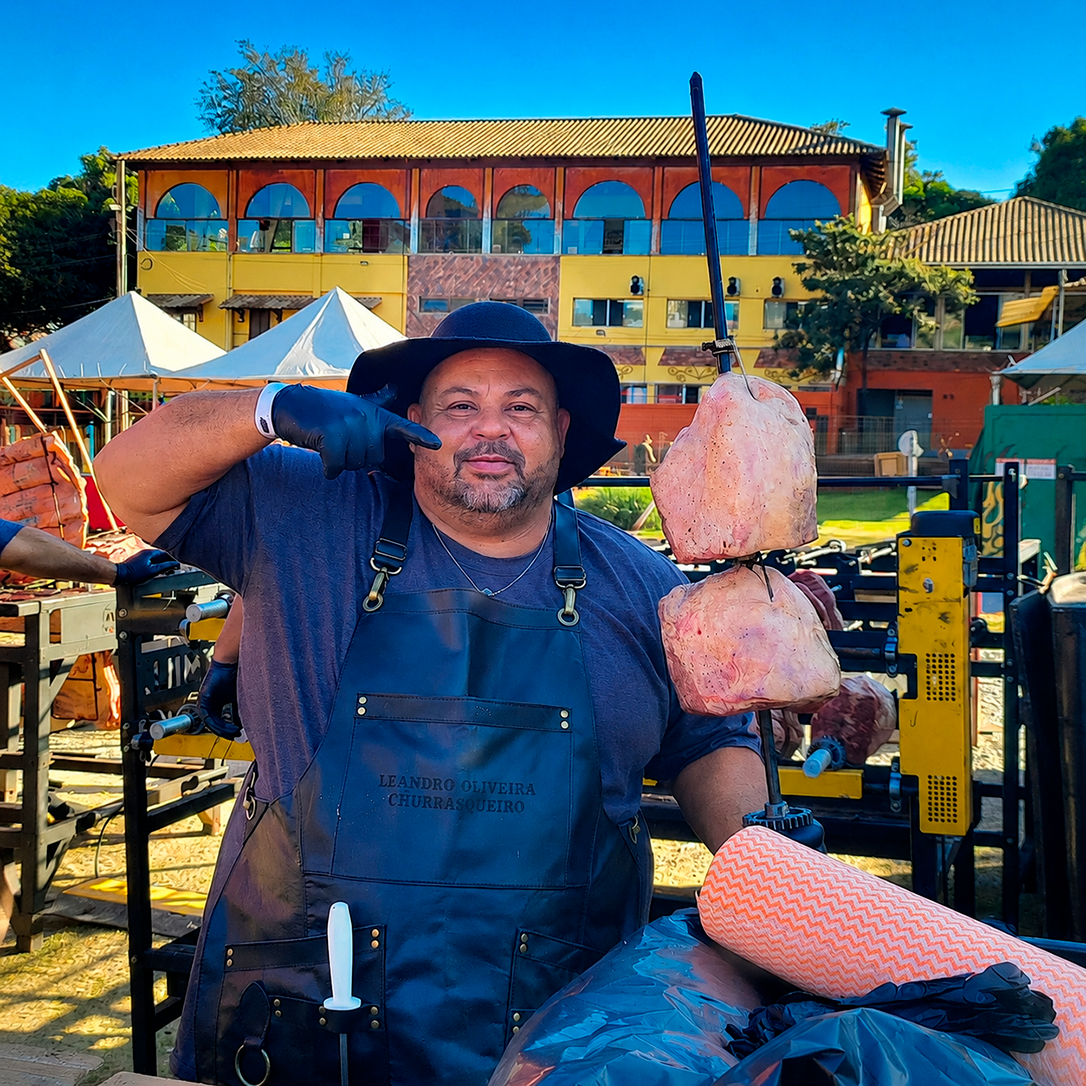 Foto do Leandro segurando um espeto com duas peças de cupim